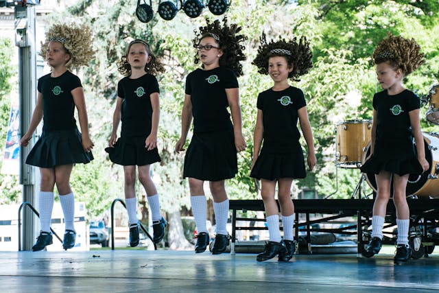 A group of young girls in black skirts and tights, showcasing 